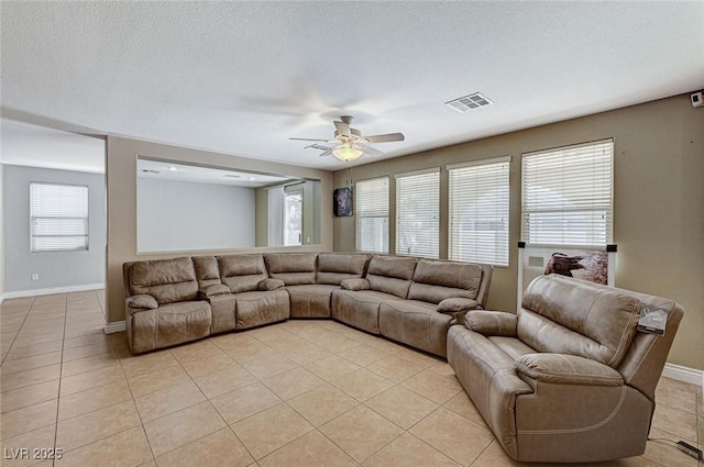 tiled living room featuring ceiling fan and a textured ceiling