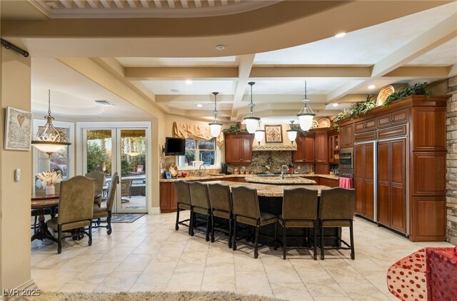 609 China Doll Pl, Henderson, NV 89012 - kitchen featuring pendant lighting, light stone counters, coffered ceiling, an island with sink, and beamed ceiling