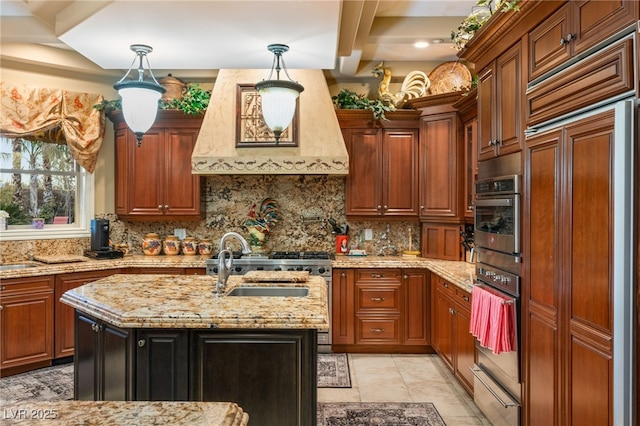 609 China Doll Pl, Henderson, NV 89012 - kitchen with decorative light fixtures, custom range hood, light stone countertops, a kitchen island with sink, and backsplash