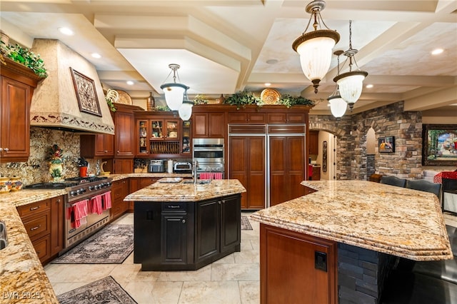 609 China Doll Pl, Henderson, NV 89012 - kitchen featuring decorative light fixtures, a center island with sink, premium appliances, custom range hood, and light stone countertops