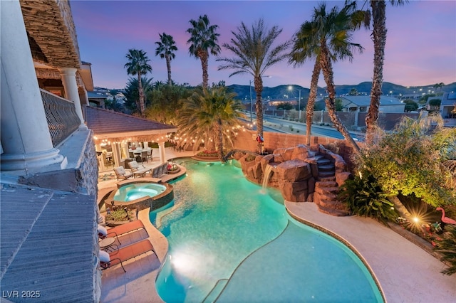 609 China Doll Pl, Henderson, NV 89012 - pool at dusk featuring a hot tub, a mountain view, and a patio area