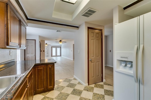 kitchen with white fridge with ice dispenser, sink, and ceiling fan