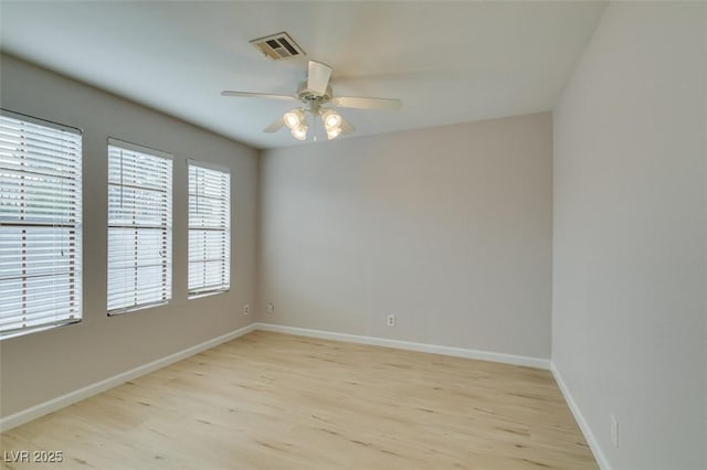 empty room with ceiling fan and light hardwood / wood-style flooring