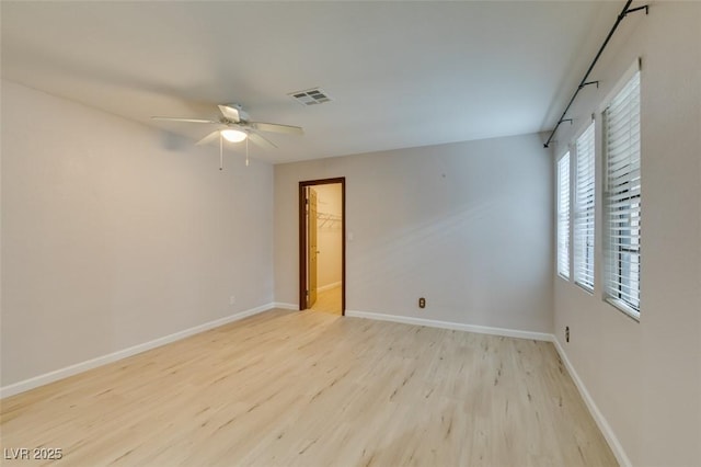 empty room with ceiling fan and light hardwood / wood-style floors