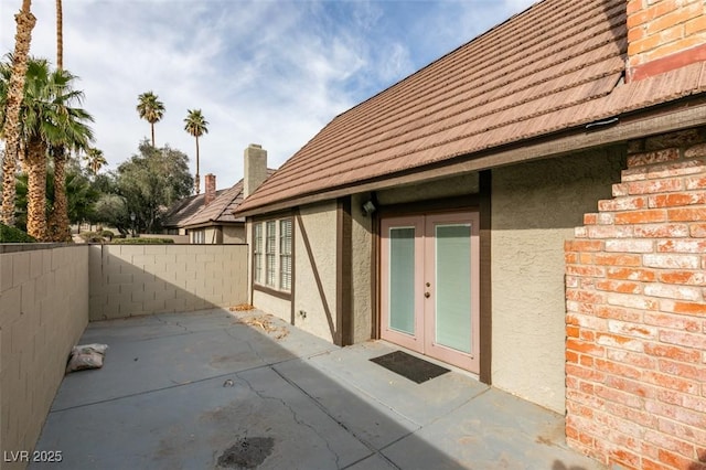 property entrance with a patio area and french doors