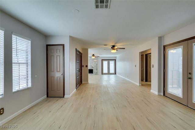 spare room with french doors, ceiling fan, and light wood-type flooring