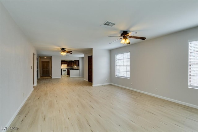 unfurnished living room with ceiling fan, plenty of natural light, and light hardwood / wood-style floors