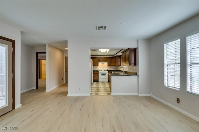 kitchen featuring white appliances, sink, and light hardwood / wood-style flooring