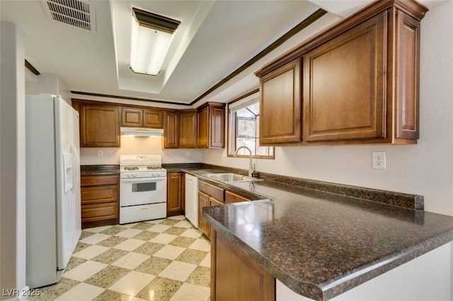 kitchen with sink, white appliances, and kitchen peninsula