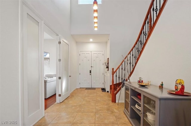 foyer entrance with light tile patterned floors and a high ceiling