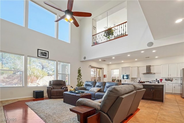 living room with ceiling fan, a healthy amount of sunlight, and light wood-type flooring