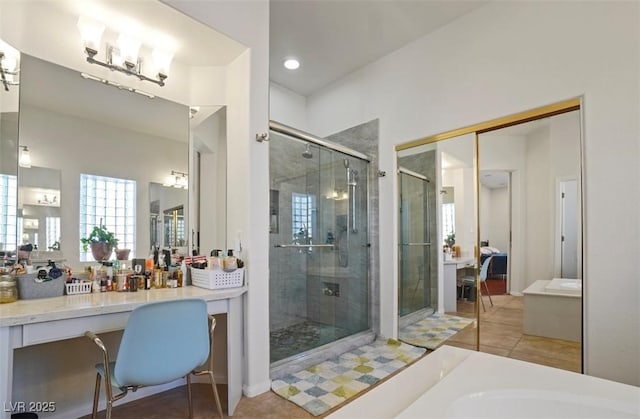 bathroom featuring shower with separate bathtub, vanity, and tile patterned floors