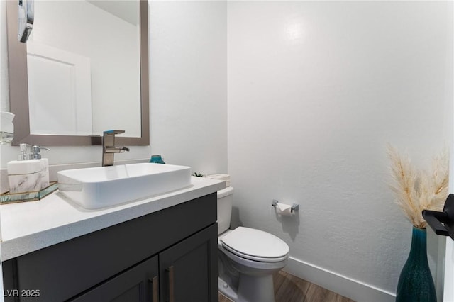 bathroom featuring vanity, wood-type flooring, and toilet