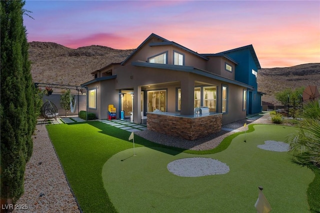 back house at dusk with a mountain view