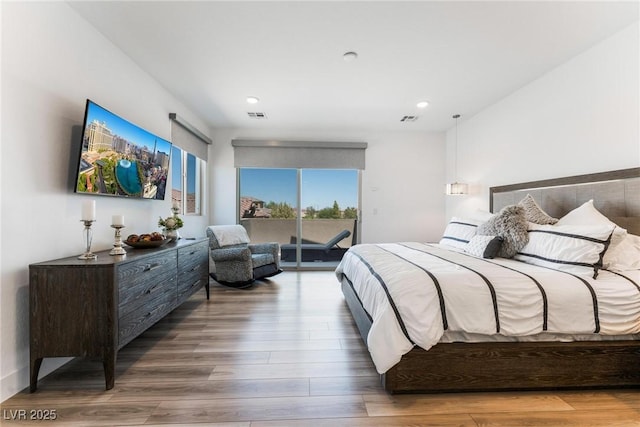 bedroom with wood-type flooring and access to outside