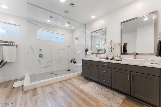 bathroom featuring tiled shower and vanity