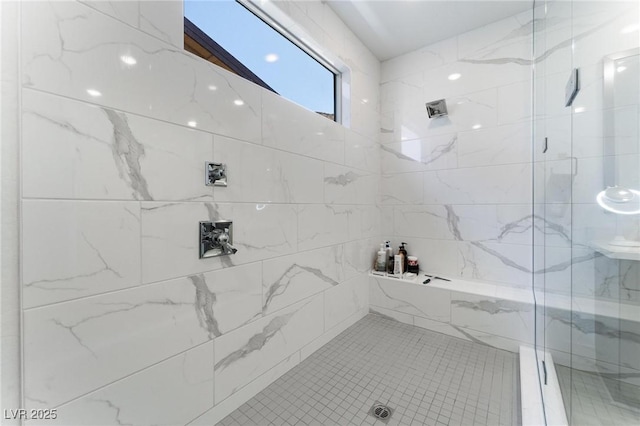 bathroom featuring tiled shower and tile patterned floors