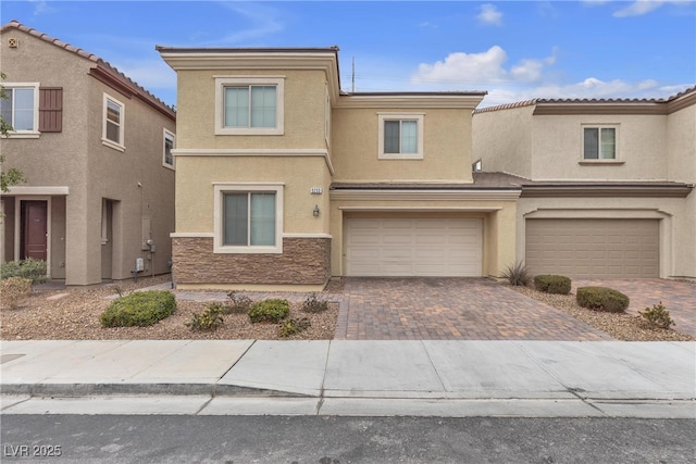 multi unit property featuring stone siding, decorative driveway, a garage, and stucco siding