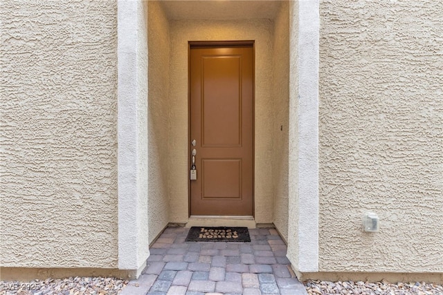 view of exterior entry with stucco siding