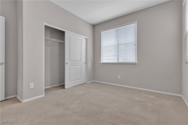 unfurnished bedroom featuring carpet floors, a closet, and baseboards