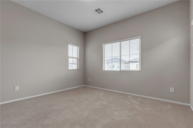 empty room with baseboards, visible vents, and light colored carpet