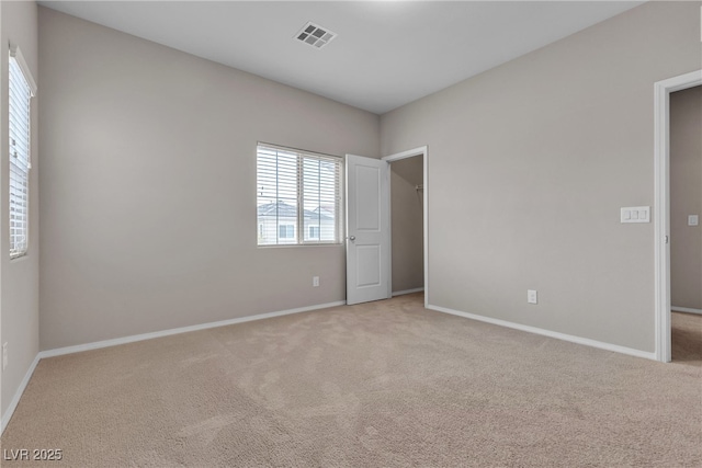 carpeted spare room with baseboards and visible vents