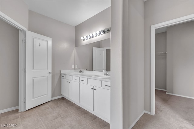 bathroom featuring a sink, baseboards, and double vanity