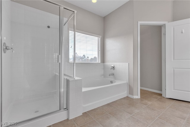 full bathroom with a stall shower, tile patterned flooring, baseboards, and a bath