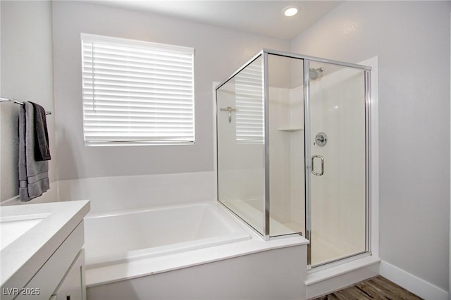 bathroom with vanity, plus walk in shower, and hardwood / wood-style floors