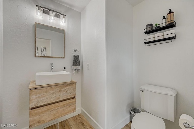 bathroom featuring vanity, toilet, and hardwood / wood-style floors