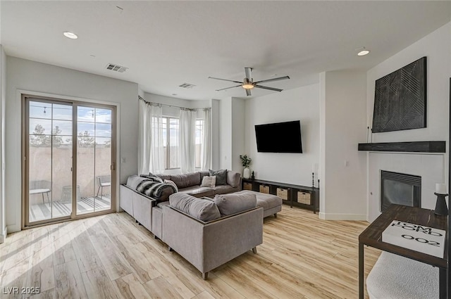 living room featuring ceiling fan and light wood-type flooring