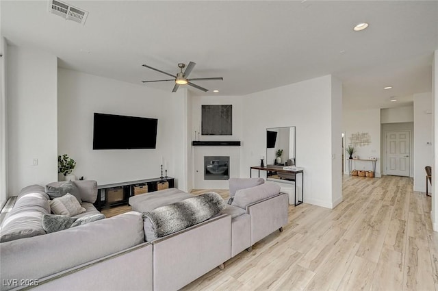 living room featuring ceiling fan and light wood-type flooring