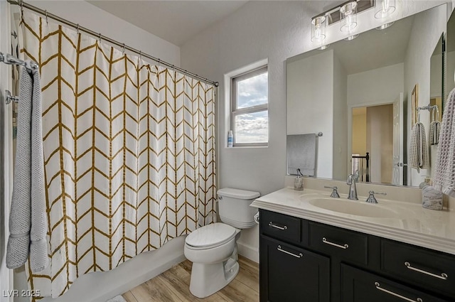 full bathroom with shower / tub combo with curtain, vanity, toilet, and hardwood / wood-style floors