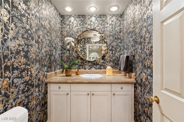 bathroom featuring vanity, a textured ceiling, and toilet