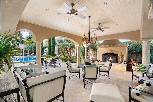 view of patio / terrace featuring exterior fireplace and ceiling fan