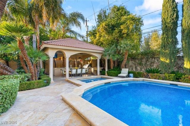 view of swimming pool with an in ground hot tub, an outdoor structure, and a patio area