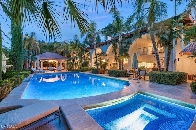 pool at dusk with a patio area