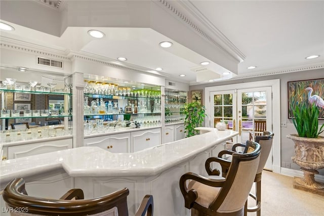 bar featuring light stone countertops, white cabinets, and french doors