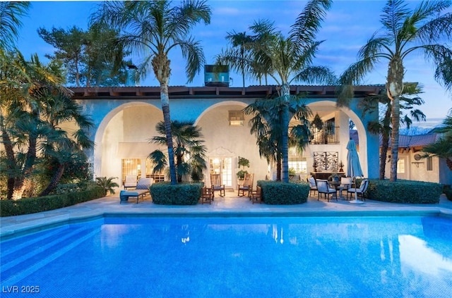 pool at dusk with a patio