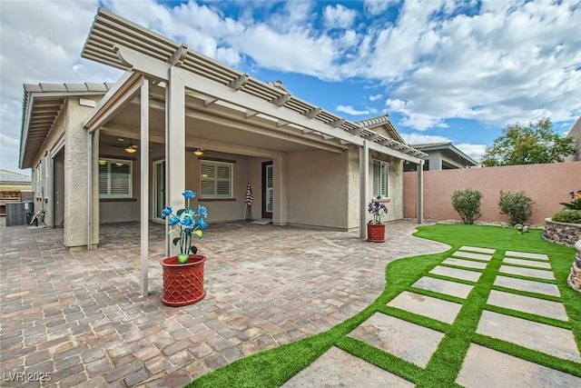 back of property with a patio, cooling unit, ceiling fan, and a pergola