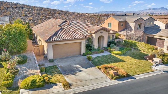 view of front of house featuring a garage, a mountain view, and a front lawn