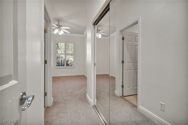 hall with ornamental molding and light colored carpet