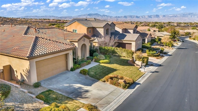 view of front of property with a mountain view, a garage, and a front yard