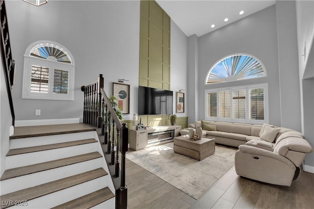 living room featuring high vaulted ceiling and hardwood / wood-style floors