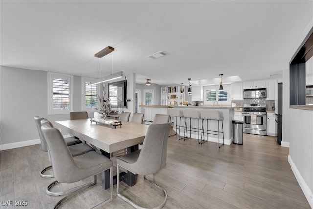 dining area with sink and light hardwood / wood-style floors