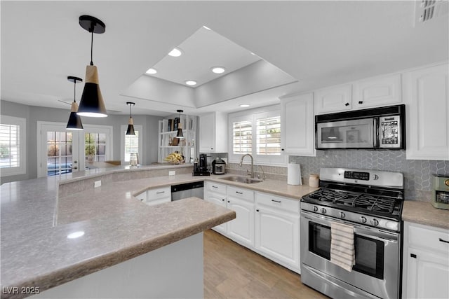 kitchen with pendant lighting, sink, white cabinets, and appliances with stainless steel finishes