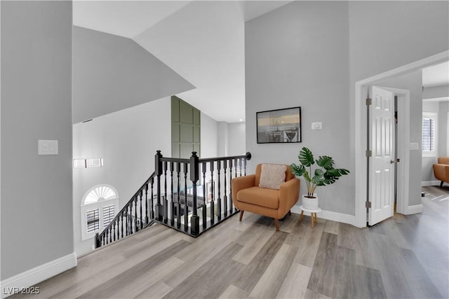 living area featuring high vaulted ceiling and light wood-type flooring