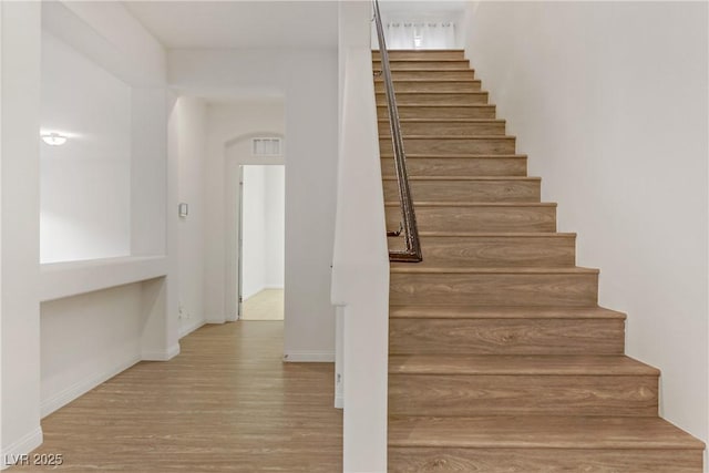 staircase with wood-type flooring