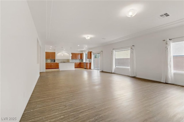 unfurnished living room with a wealth of natural light and light hardwood / wood-style floors