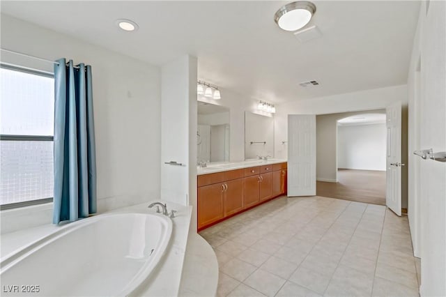 bathroom featuring vanity, tile patterned flooring, and a bathtub